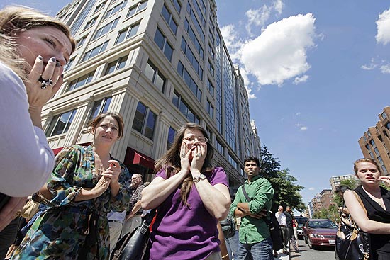 Funcionários se reúnem na calçada após descer assustados do prédio em que trabalhavam, em Washington